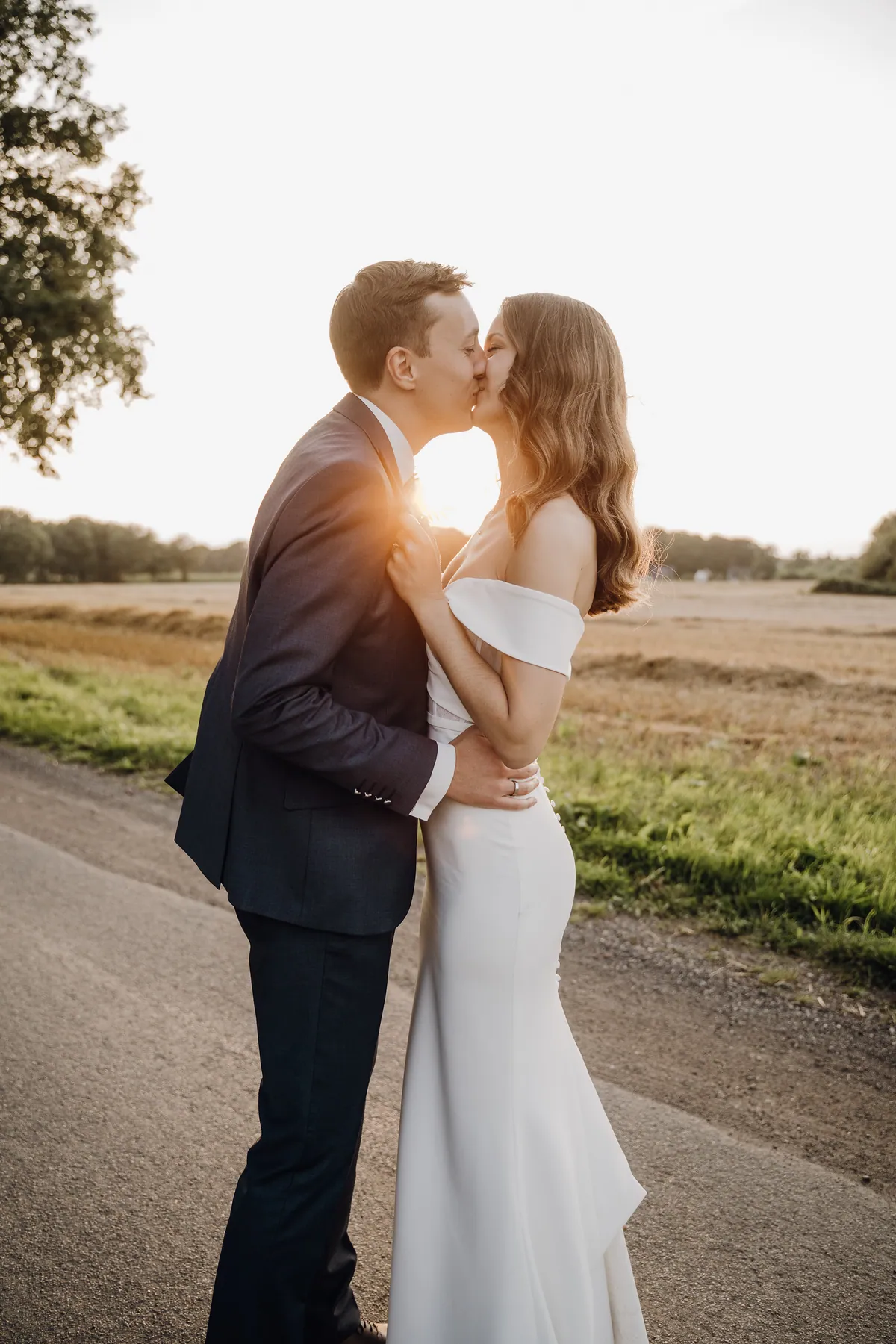 Auf der Landstraße küssen sich Luisa und Jonas, sie hält sein Revers, seine Hand mit dem Ring liegt an ihrer Taille, zwischen ihnen bricht die Abendsonne durch.